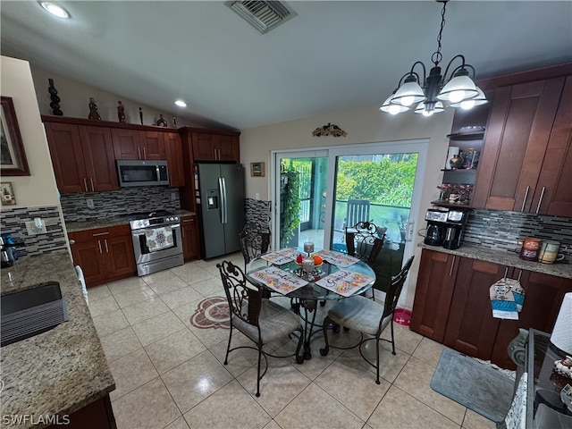 kitchen featuring decorative backsplash, stainless steel appliances, decorative light fixtures, and light tile patterned floors