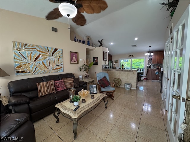 living room with tile patterned floors, french doors, ceiling fan with notable chandelier, and vaulted ceiling