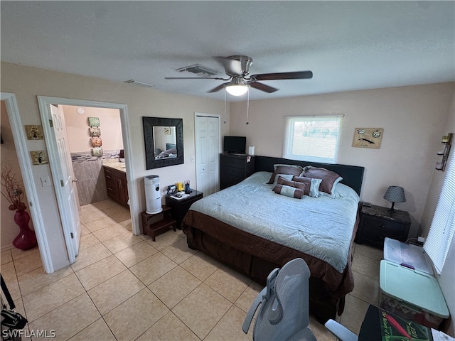 tiled bedroom with ensuite bath and ceiling fan