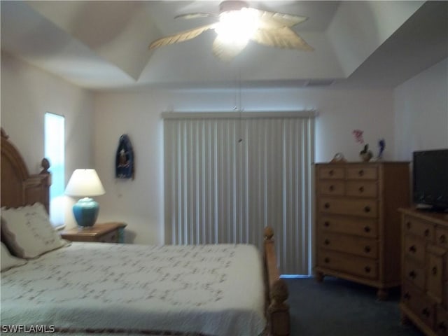 bedroom featuring lofted ceiling, dark carpet, and ceiling fan