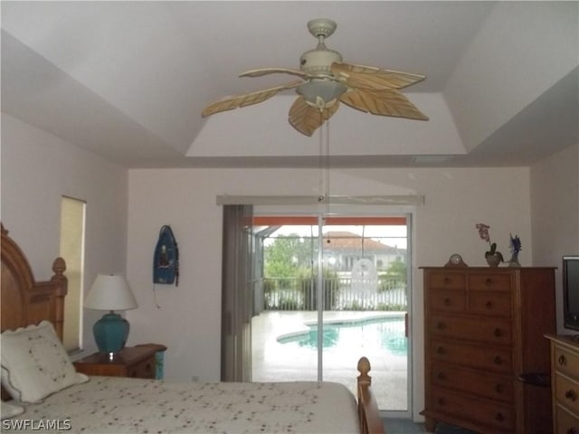 bedroom with ceiling fan, a tray ceiling, and access to outside