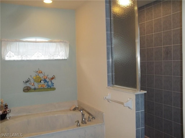 bathroom featuring shower with separate bathtub