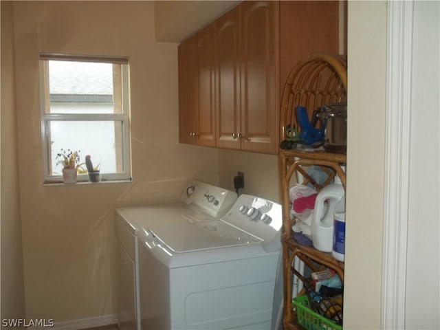 washroom with cabinets and washing machine and clothes dryer