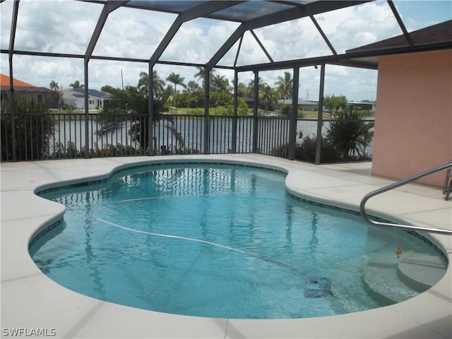 view of swimming pool featuring a water view, glass enclosure, and a patio area