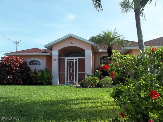 view of exterior entry with a lawn