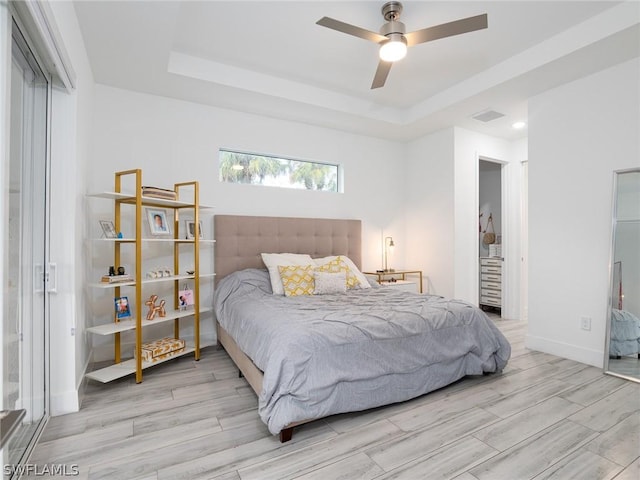 bedroom with ceiling fan and a tray ceiling