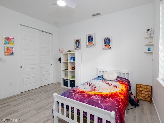 bedroom with ceiling fan, a closet, and hardwood / wood-style flooring