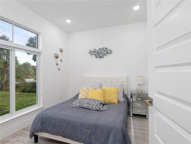 bedroom featuring multiple windows and hardwood / wood-style flooring