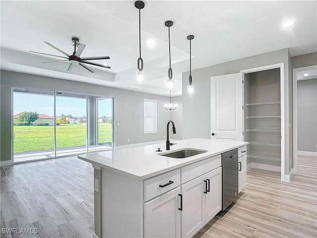 kitchen featuring white cabinets, ceiling fan with notable chandelier, dishwasher, a center island with sink, and sink