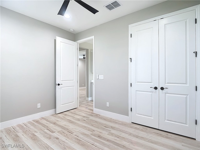 unfurnished bedroom with a closet, light hardwood / wood-style floors, and ceiling fan