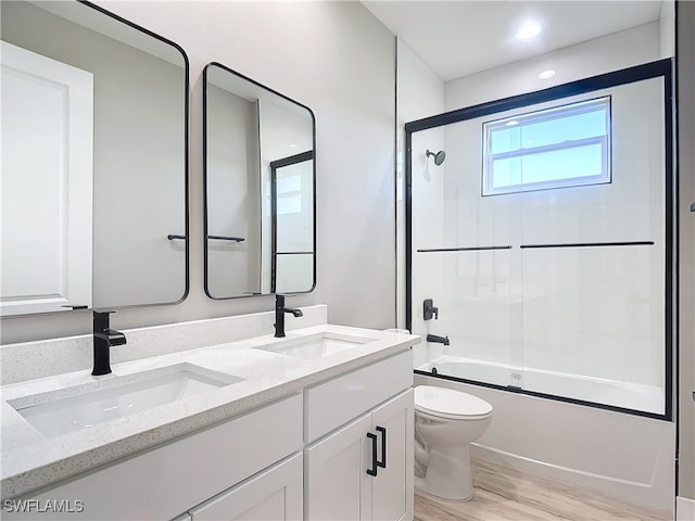 full bathroom with vanity, hardwood / wood-style flooring, enclosed tub / shower combo, and toilet