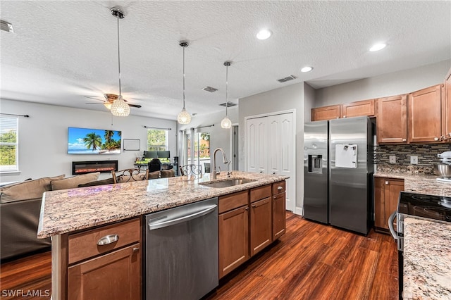 kitchen featuring appliances with stainless steel finishes, sink, pendant lighting, and a textured ceiling