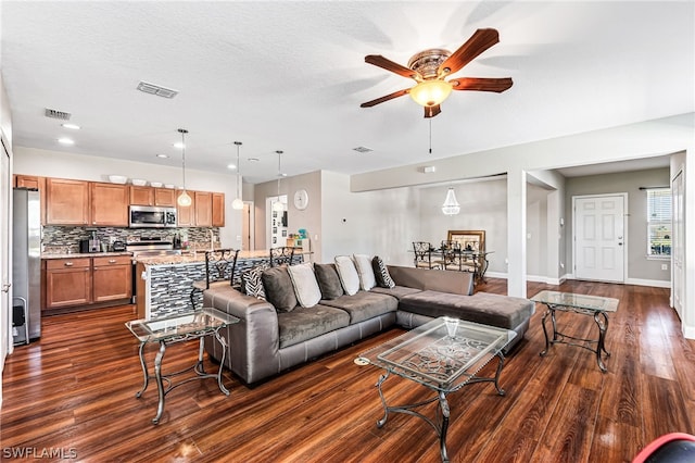 living room with ceiling fan and dark hardwood / wood-style floors