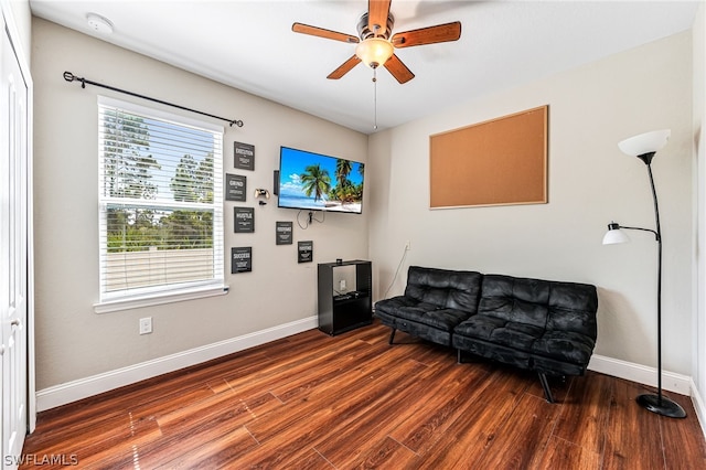 living room with ceiling fan and dark hardwood / wood-style flooring