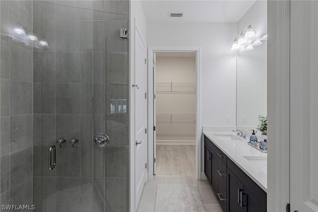 bathroom featuring tile patterned flooring, vanity, and a shower with shower door