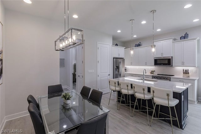 dining room with sink and light hardwood / wood-style flooring