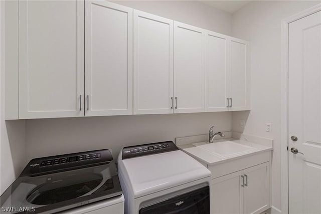 laundry room with cabinets, washing machine and dryer, and sink