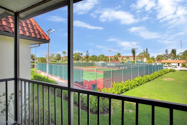 view of tennis court featuring a lawn