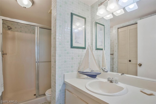 bathroom featuring tile walls, an enclosed shower, toilet, and vanity