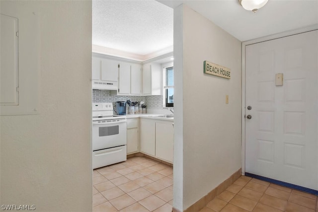 kitchen featuring white electric range, a textured ceiling, white cabinets, light tile patterned flooring, and sink