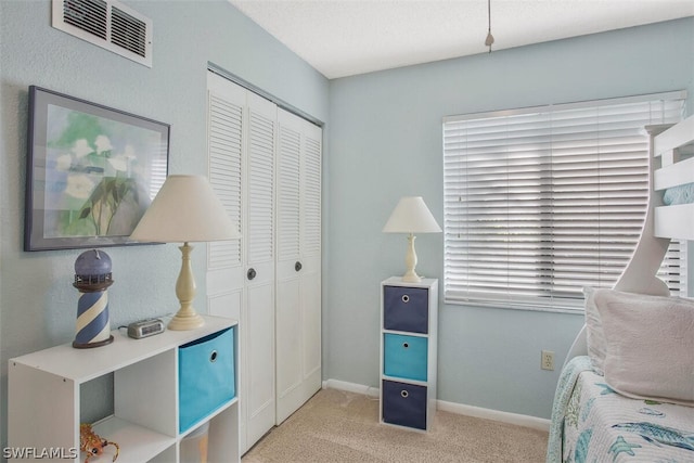 bedroom featuring a closet and light carpet