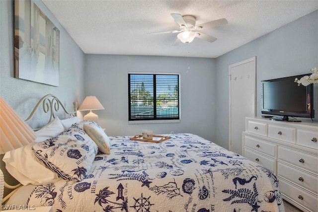 bedroom featuring ceiling fan and a textured ceiling