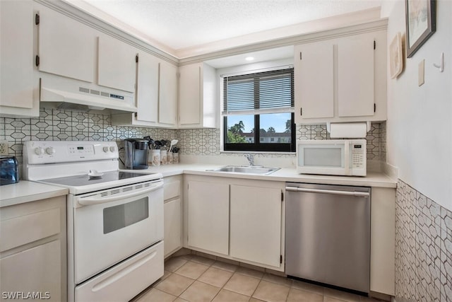 kitchen featuring white appliances, white cabinets, sink, and light tile patterned floors