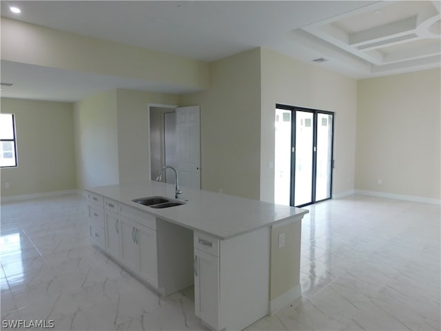 kitchen with white cabinets, light tile patterned floors, a kitchen island with sink, and sink