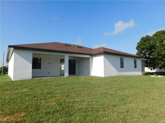 back of house with a patio and a lawn