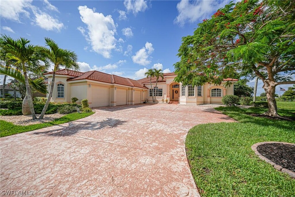 mediterranean / spanish-style house featuring a garage and a front yard