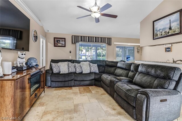 living room featuring lofted ceiling, ceiling fan, and ornamental molding