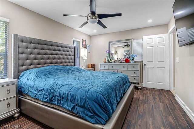 bedroom featuring ceiling fan, dark hardwood / wood-style flooring, and multiple windows