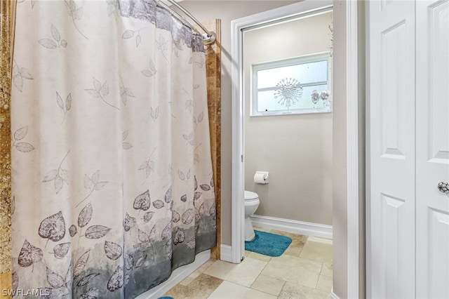 bathroom featuring toilet and curtained shower