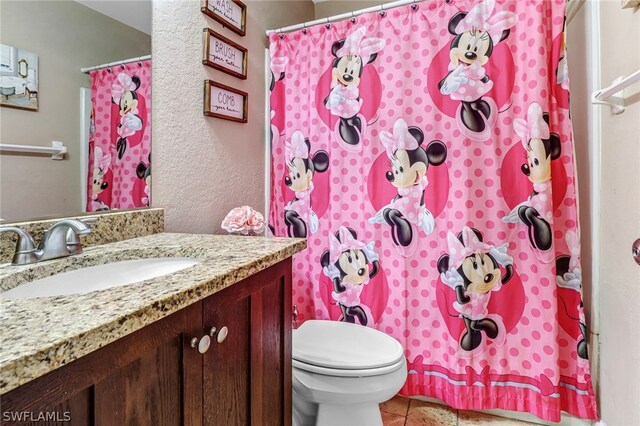 bathroom with tile patterned floors, vanity, and toilet