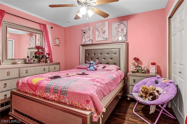 bedroom with dark hardwood / wood-style flooring, ceiling fan, and a closet