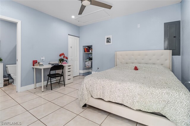 bedroom with electric panel, tile patterned floors, ensuite bathroom, ceiling fan, and a closet