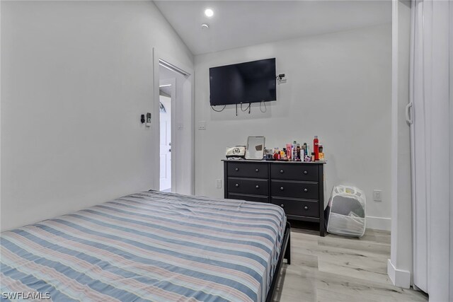 bedroom with light hardwood / wood-style floors and vaulted ceiling