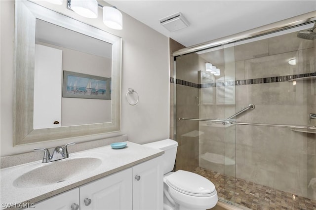 bathroom with vanity, toilet, and a shower stall