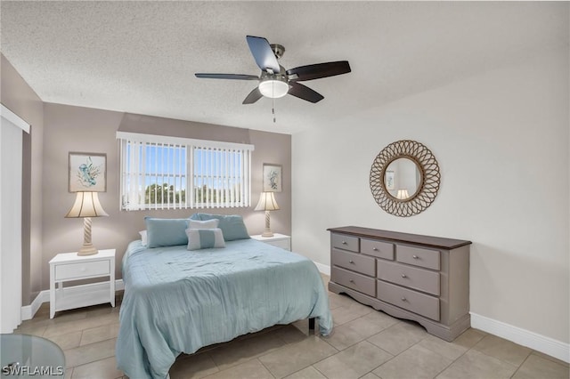 tiled bedroom featuring baseboards, a textured ceiling, and a ceiling fan