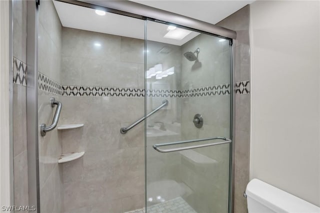 bathroom featuring a shower stall and toilet