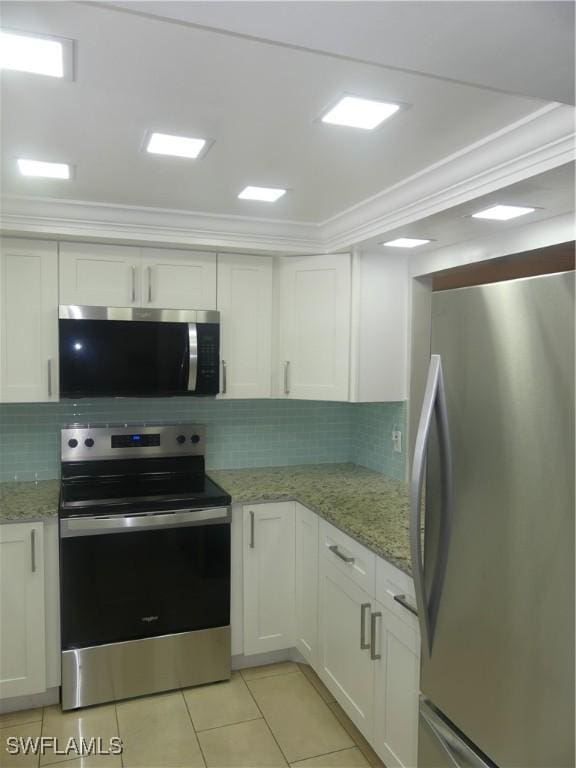 kitchen with tasteful backsplash, crown molding, light tile patterned floors, appliances with stainless steel finishes, and white cabinetry