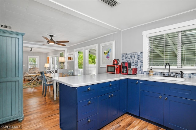 kitchen featuring sink, ceiling fan, blue cabinetry, and light hardwood / wood-style floors