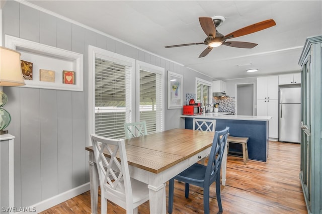 dining room with ornamental molding, sink, light hardwood / wood-style flooring, and ceiling fan