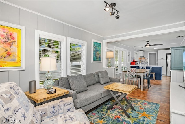 living room with ceiling fan, ornamental molding, dark hardwood / wood-style flooring, and a healthy amount of sunlight