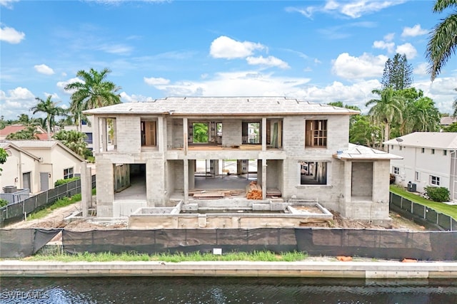 rear view of house with a patio area, a balcony, and a water view