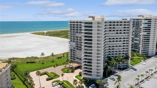 drone / aerial view featuring a water view and a beach view