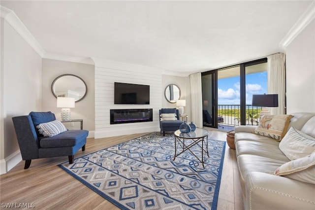 living room featuring wood-type flooring, ornamental molding, and floor to ceiling windows