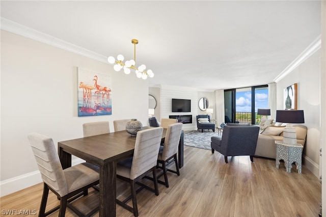 dining space featuring ornamental molding, light hardwood / wood-style floors, and a chandelier