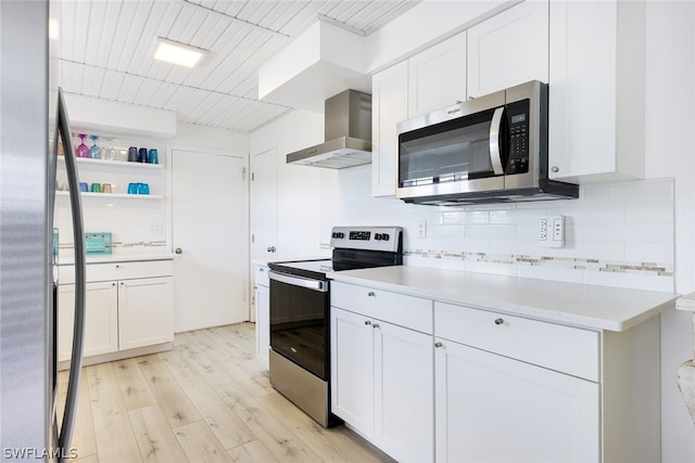 kitchen with stainless steel appliances, decorative backsplash, light wood-type flooring, wall chimney exhaust hood, and white cabinets