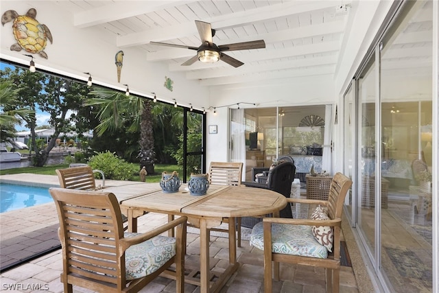 sunroom featuring ceiling fan and beamed ceiling